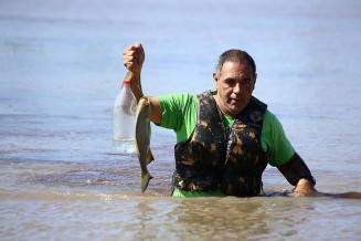 Agente da Defesa Civil mostra armadilha de pesca ilegal