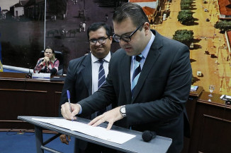 Legenda: Alan Guedes e Madson Valente durante cerimônia assinatura da Lei